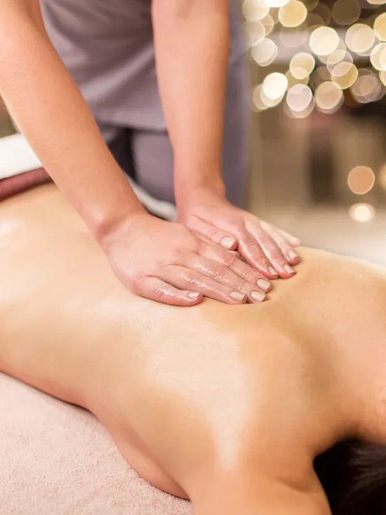 Entspannende Rückenmassage im Spa bei warmem Licht und beruhigender Atmosphäre