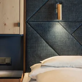 Modern hotel room with padded dark fabric headboard and built-in reading light