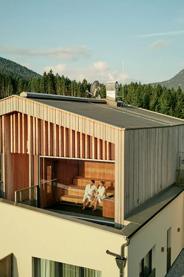 Mountain hotel with rooftop sauna and pool overlooking forest and alpine village