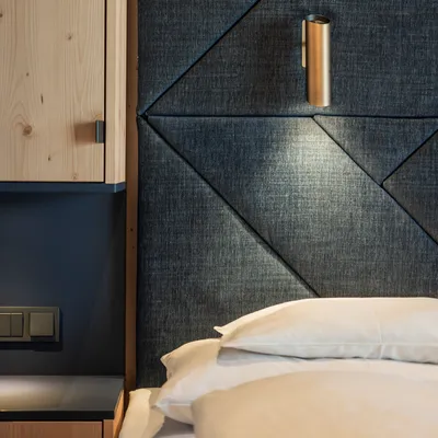 Modern hotel room with padded dark fabric headboard and built-in reading light