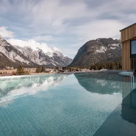 Infinity-Pool im Bergresort mit Alpenblick und moderner Holzarchitektur