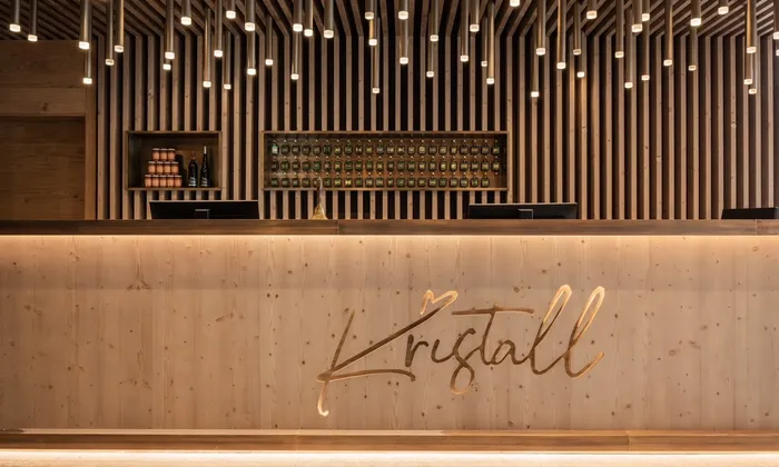 Moderne hölzerne Hotelrezeption mit Kristall-Logo und warmer Ambientebeleuchtung