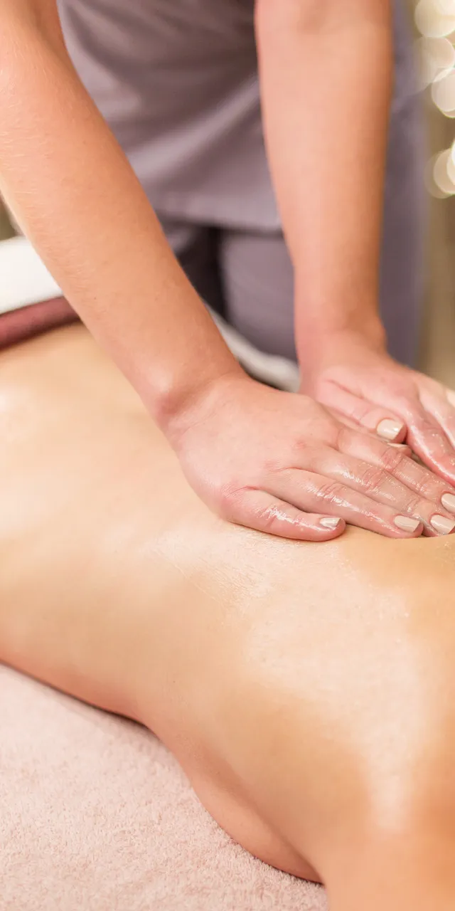 Entspannende Rückenmassage im Spa bei warmem Licht und beruhigender Atmosphäre