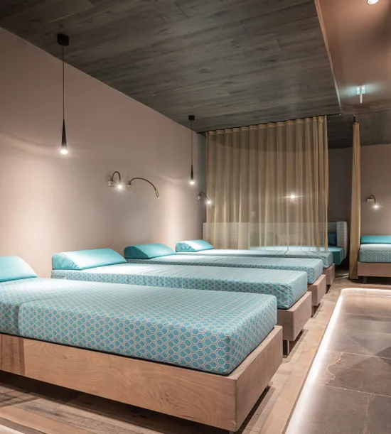 Moderner Spa-Ruheraum mit türkisfarbenen Liegen und stimmungsvoller Beleuchtung