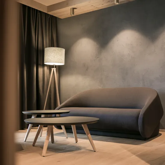 Modern living room with gray sofa, round coffee tables, and floor lamp on wooden flooring