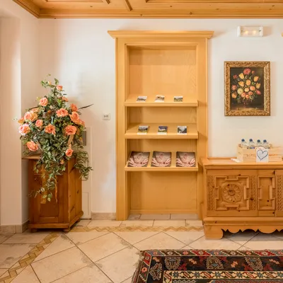 Cozy hotel lobby with wood paneling, floral arrangement, brochures, and a crate of water bottles