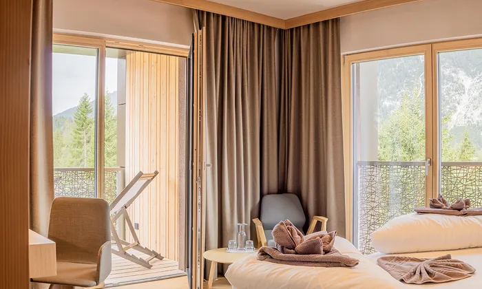 Cozy hotel room with balcony, mountain views, modern furnishings and double bed