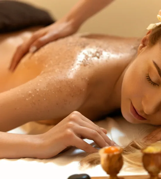 Frau genießt entspannendes Spa-Körperpeeling mit natürlichen Ölen und Peelingbehandlung